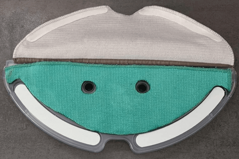 Ein Schwammtuch wird unter den Wischmopp eines Saug-Wisch-Roboters geklemmt
